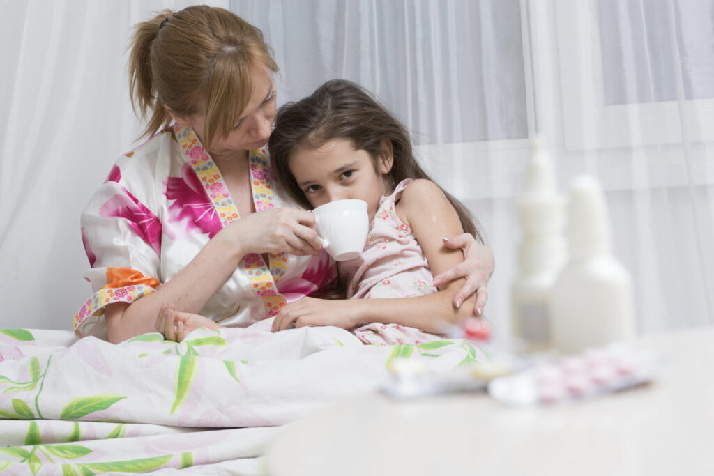 Mother comforting daughter with sore throat