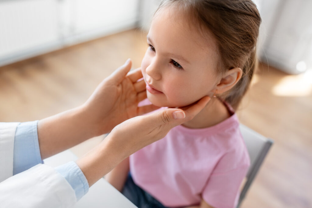 A little girl is being examined by a doctor.